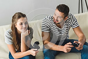 beautiful young couple playing games with gamepads