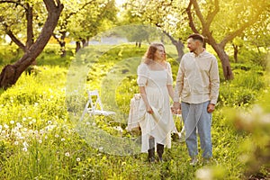 Beautiful young couple in a romantic place, spring blooming apple orchard. Happy joyful couple enjoy each other