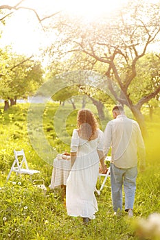 Beautiful young couple in a romantic place, spring blooming apple orchard. Happy joyful couple enjoy each other