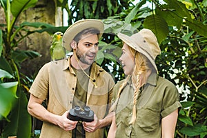 beautiful young couple in safari suits with binoculars hiking together