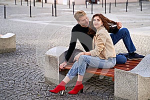 Beautiful young couple sitting on a bench in the city during a romantic date