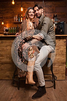 Beautiful young couple sitting at the counter and smiling to the camera