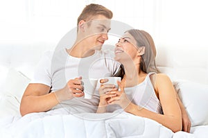 Beautiful young couple on soft bed in morning