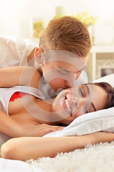Beautiful young couple on soft bed in morning