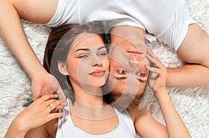 Beautiful young couple on soft bed in morning