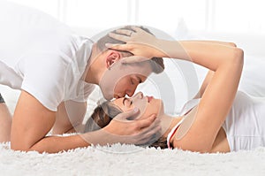 Beautiful young couple on soft bed in morning