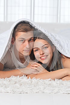 Beautiful young couple on soft bed in morning