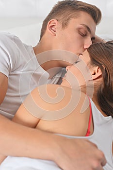 Beautiful young couple on soft bed in morning