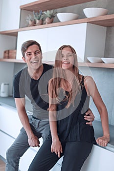 Beautiful young couple standing in home kitchen