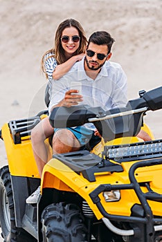 beautiful young couple taking selfie while sitting on ATV