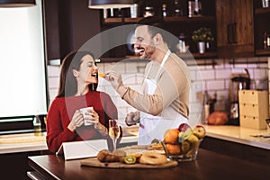 Young couple is using a digital tablet and smiling while cooking in kitchen at home