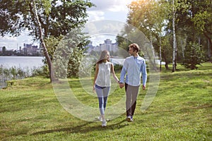 beautiful young couple on a walk along the shore of the city lak