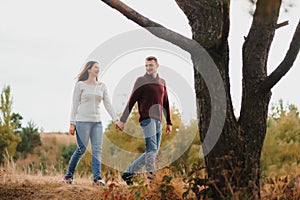 Beautiful young couple walking in autumn park