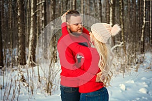 Beautiful young couple in winter in the woods, hug, happy romance