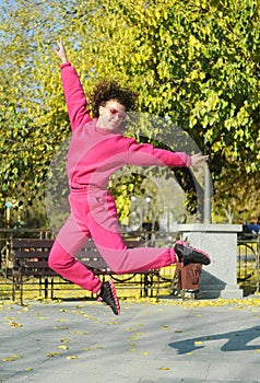 Beautiful young curly hair woman in pink sportswear and middle age 50s woman doing sports outdoors.