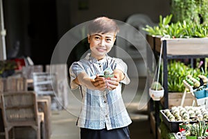 Beautiful young customer selecting fresh flowers in Parisian flower shop or on market