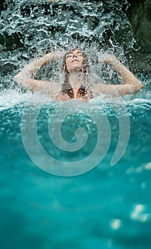 beautiful young cute sexy redhead woman in Bikini with closed eyes, raises her arms, enjoying the feeling of splashing water of