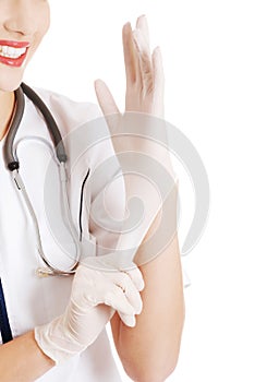 Beautiful young doctor or nurse putting sterile gloves.