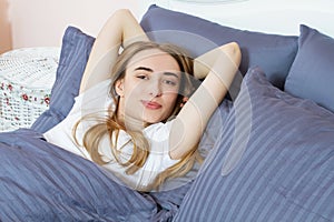 Beautiful young dreaming girl lying in her bed in the morning with closed eyes. health and beauty