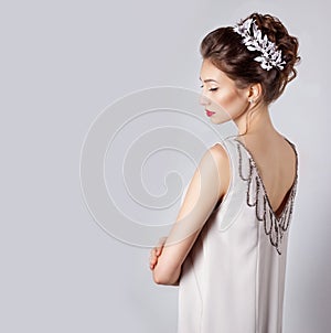 Beautiful young elegant happy smiling woman with red lips, beautiful stylish hairstyle with white flowers in her hair