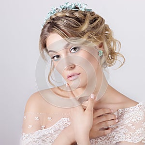 Beautiful young elegant sweet girl in the image of a bride with hair and flowers in her hair , delicate wedding makeup