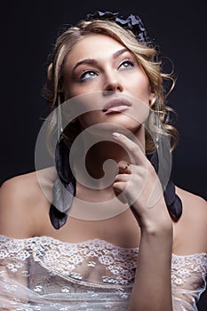 Beautiful young elegant sweet girl in the image of a bride with hair and flowers in her hair, delicate wedding makeup