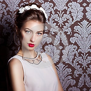 Beautiful young elegant woman with red lips, beautiful stylish hairstyle with white flowers in her hair, the way