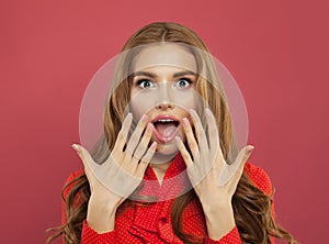 Beautiful young excited surprised woman with opened mouth on colorful bright pink background. Positive emotion.