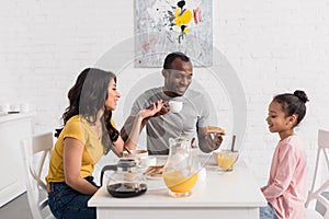 beautiful young family having breakfast