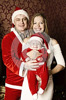 Beautiful young family with little cute baby girl on Christmas