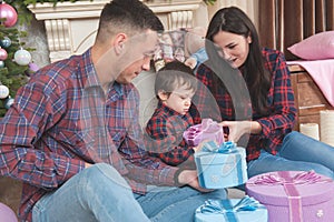 Beautiful young family in plaid shirts wife husband child with c