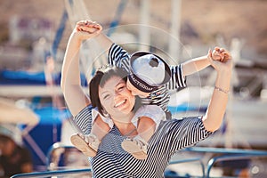 Beautiful young family of two walking along wooden jetty. Woman with son on pier