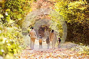 Beautiful young family on a walk in autumn forest.