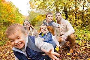 Beautiful young family on a walk in autumn forest.