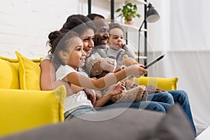 beautiful young family watching tv together