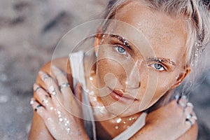 Beautiful young fashion model on the beach. Close up portrait of boho model with sparkling boho accessories