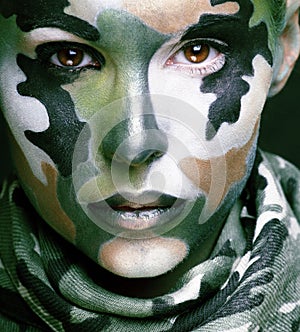 Beautiful young fashion woman with military style clothing and face paint make-up, khaki colors, halloween celebration