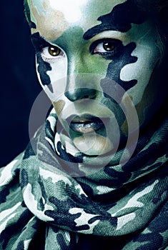 Beautiful young fashion woman with military style clothing and face paint make-up, khaki colors, halloween celebration
