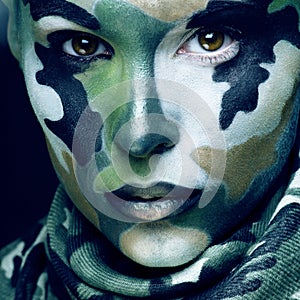 Beautiful young fashion woman with military style clothing and face paint make-up, khaki colors, halloween celebration