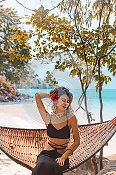 Beautiful young fashionable woman in black dress posing at the beach