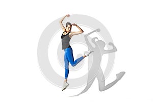 Beautiful young female athlete stretching on white studio background with shadows