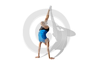 Beautiful young female athlete stretching on white studio background with shadows