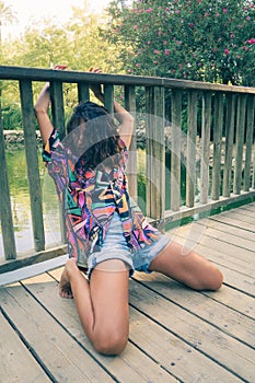 Beautiful young female dancing on a bridge in a park