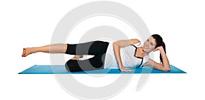 Beautiful young female exercising on a blue matt photo
