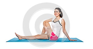 Beautiful young female exercising on a blue matt photo