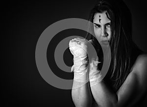 Beautiful young female fighter after the fight on a dark background. girls in martial arts. black and white. free space