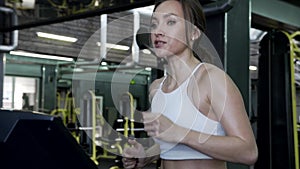 Beautiful Young Female Fitnes Model Is Running On A Treadmill