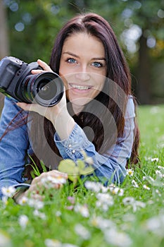 Beautiful young female photographer checking pictures on camera