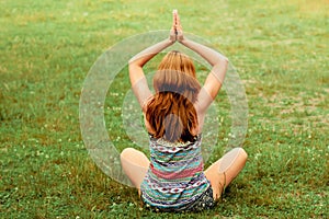 Beautiful young  female relaxes in yoga pose in green nature. Beauty woman doing yoga. Healthy and yoga concept.