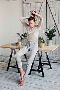 Beautiful young feminine woman relaxing at home in lazy weekend morning with cup of coffee